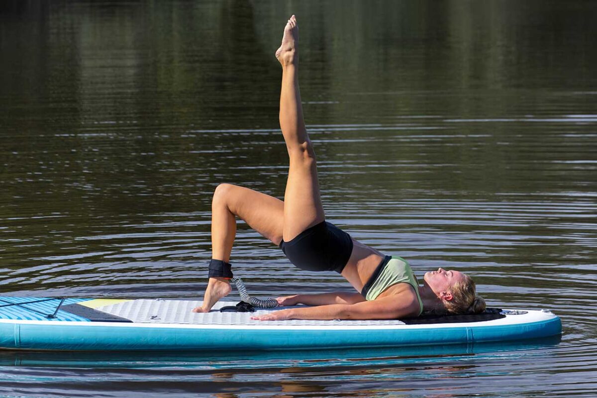 Eine Frau betreibt Yoga auf dem Stand Up Paddle